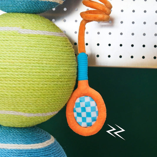 Close-up of the mini tennis racket toy on its elastic cord