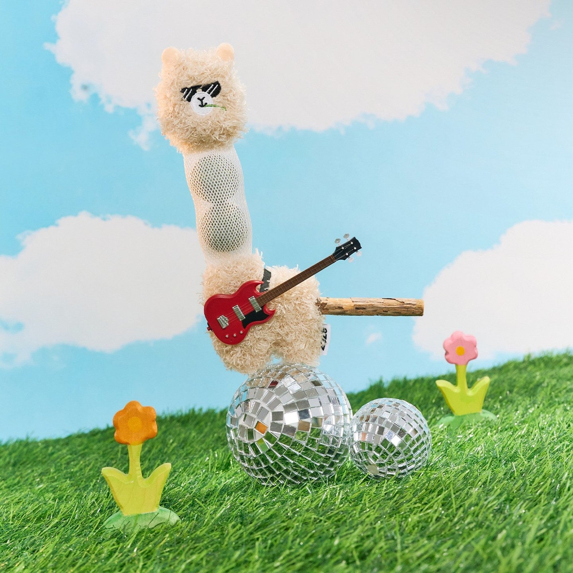 Alpaca cat toy with a toy guitar on a disco ball