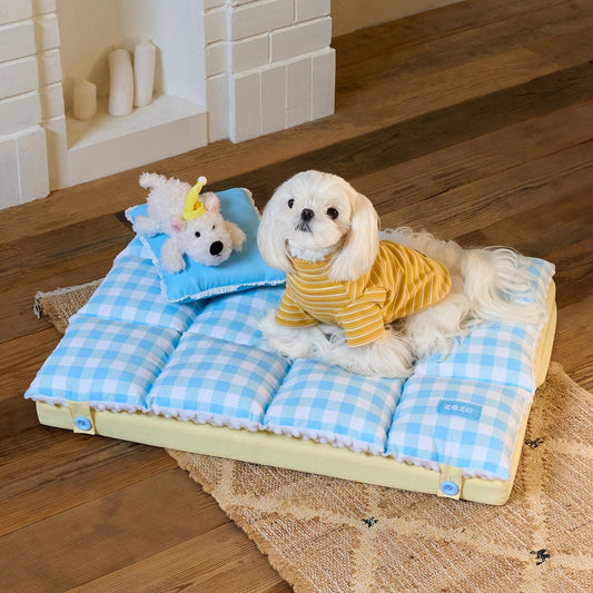 Maltese on the ZEZE gingham nap mat with pillow and plush puppy by a fireplace
