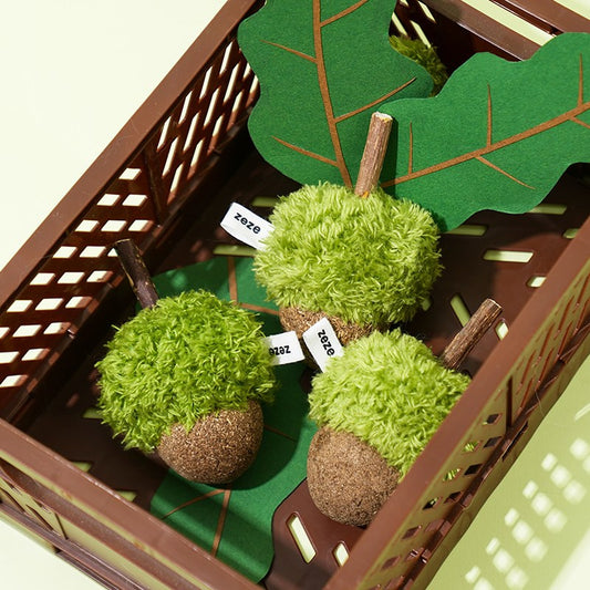 Three acorn cat toys in a brown crate with felt leaves