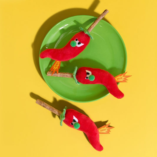 Chili pepper cat toys with silvervine sticks on a green plate
