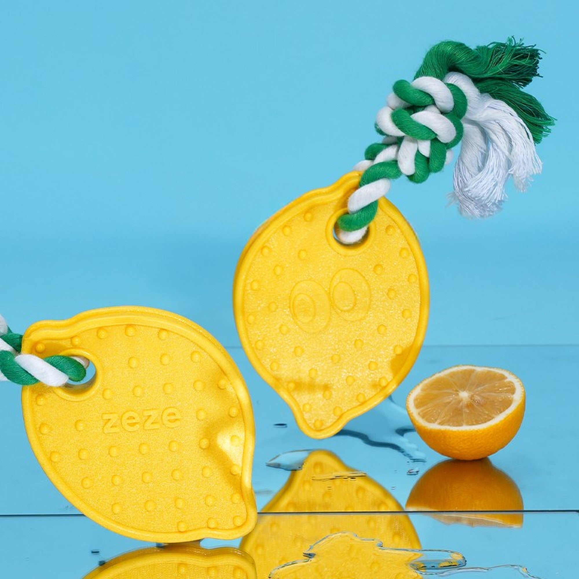 Two lemon chew toys beside a sliced lemon