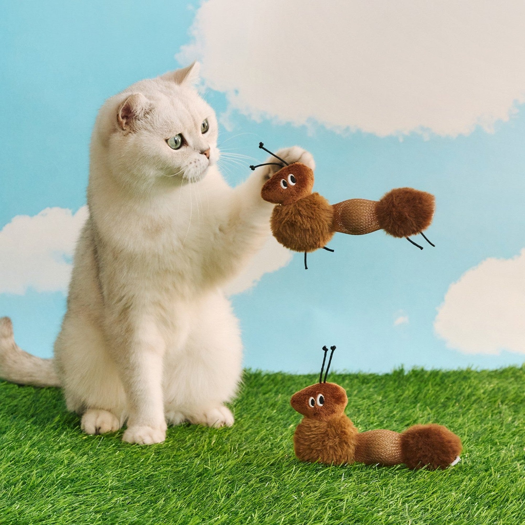 White cat batting the ZEZE Little Ant catnip cat toy