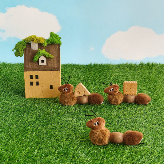Three ant cat toys outside a tiny house