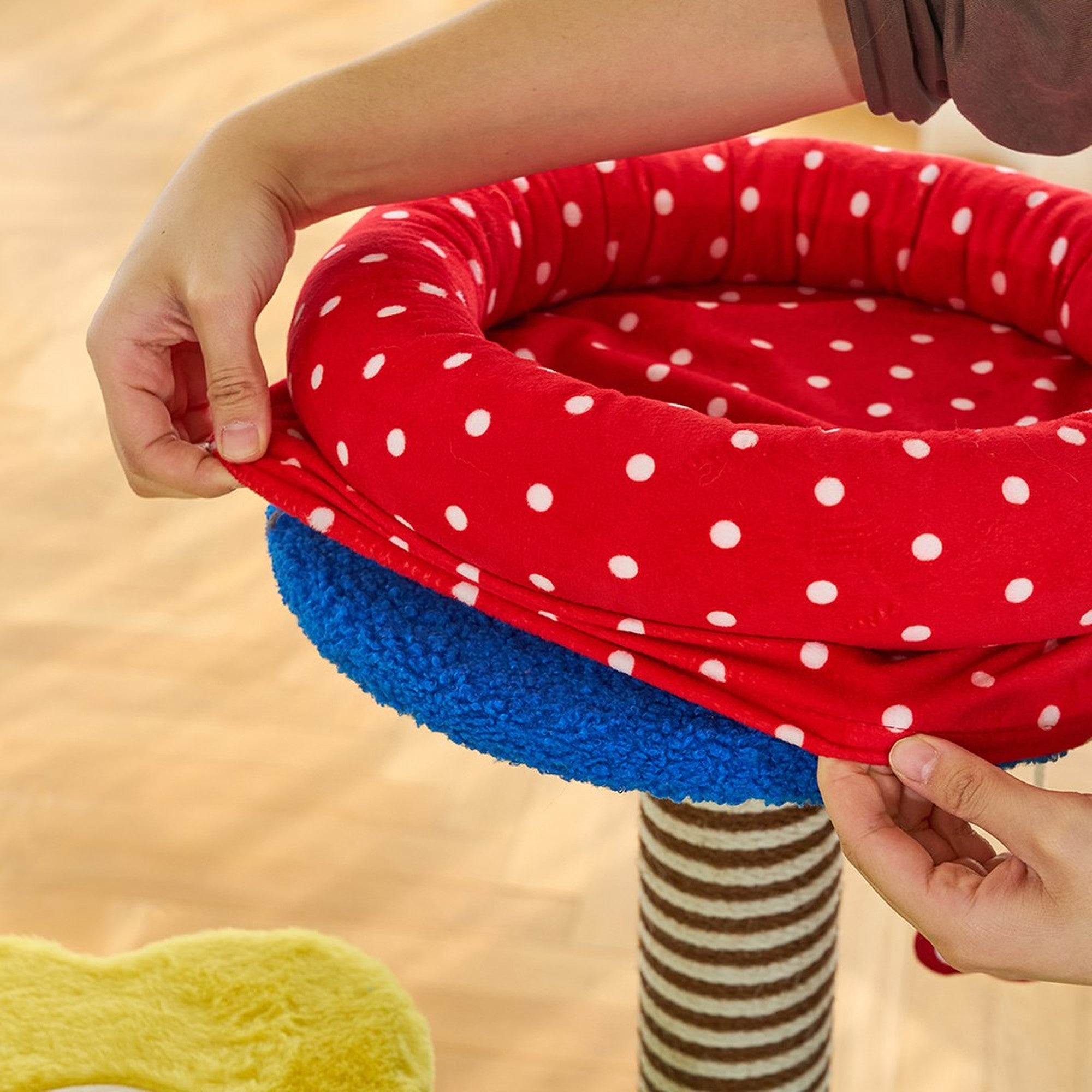Fitting the stretch cover onto the polka-dot top bed