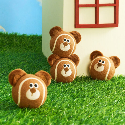 Stack of Mocha the Bear tennis balls by a toy house
