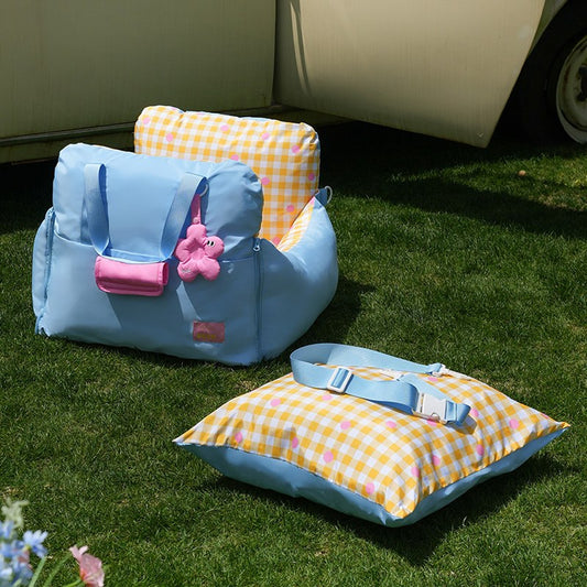 Car seat bed with cushion and seat strap on grass