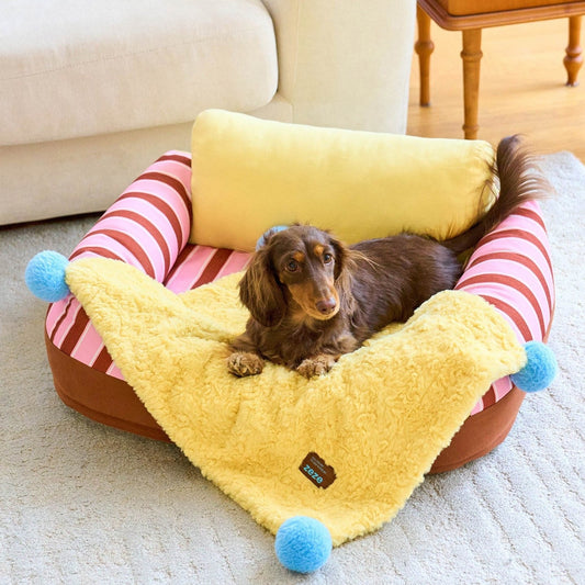 ZEZE pompom blanket lining a pet sofa with a dachshund