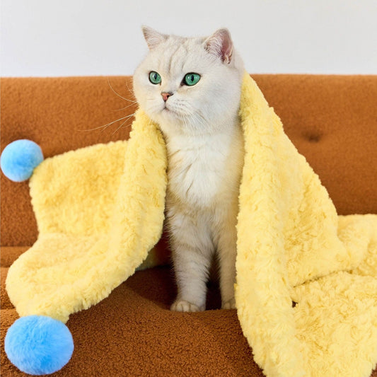 White cat under the ZEZE yellow pompom blanket