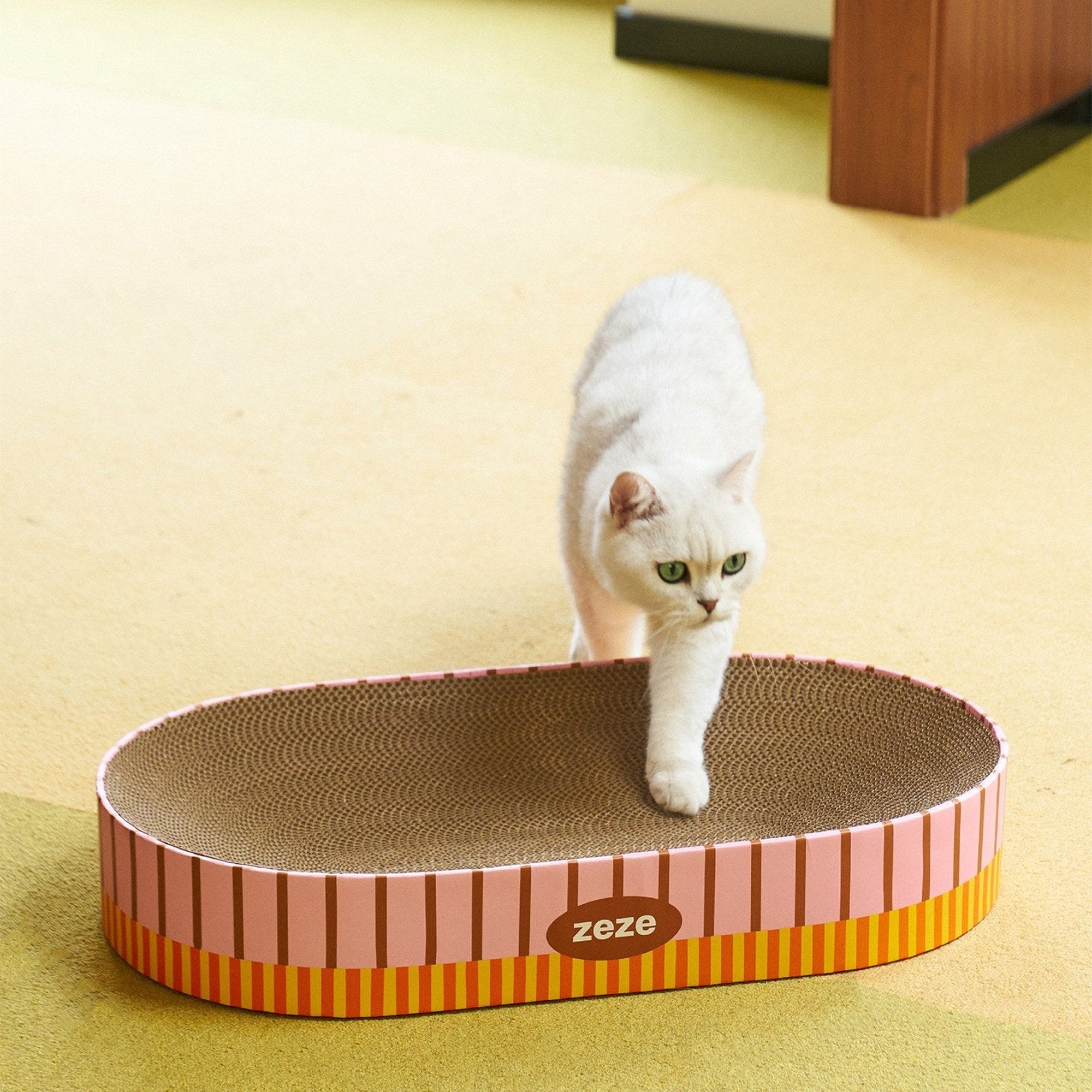 Cat stepping out of the ZEZE Retro Stripe oval scratcher