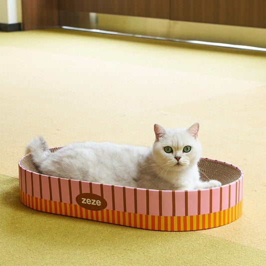 Cat lounging in the oval cardboard scratcher