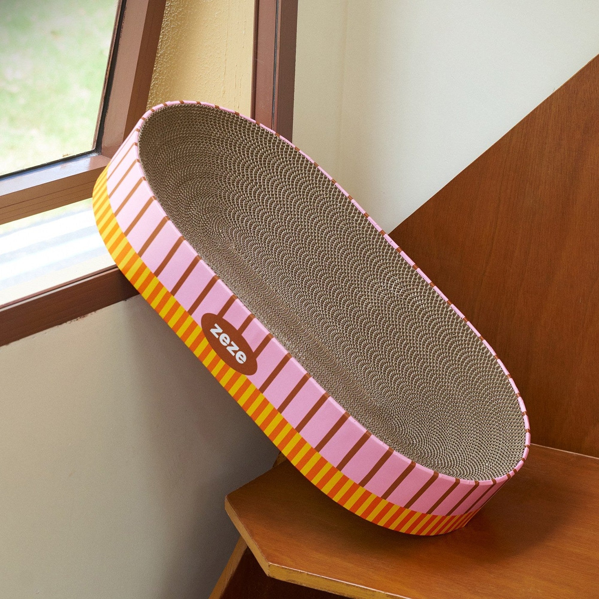 Oval scratcher propped by a window