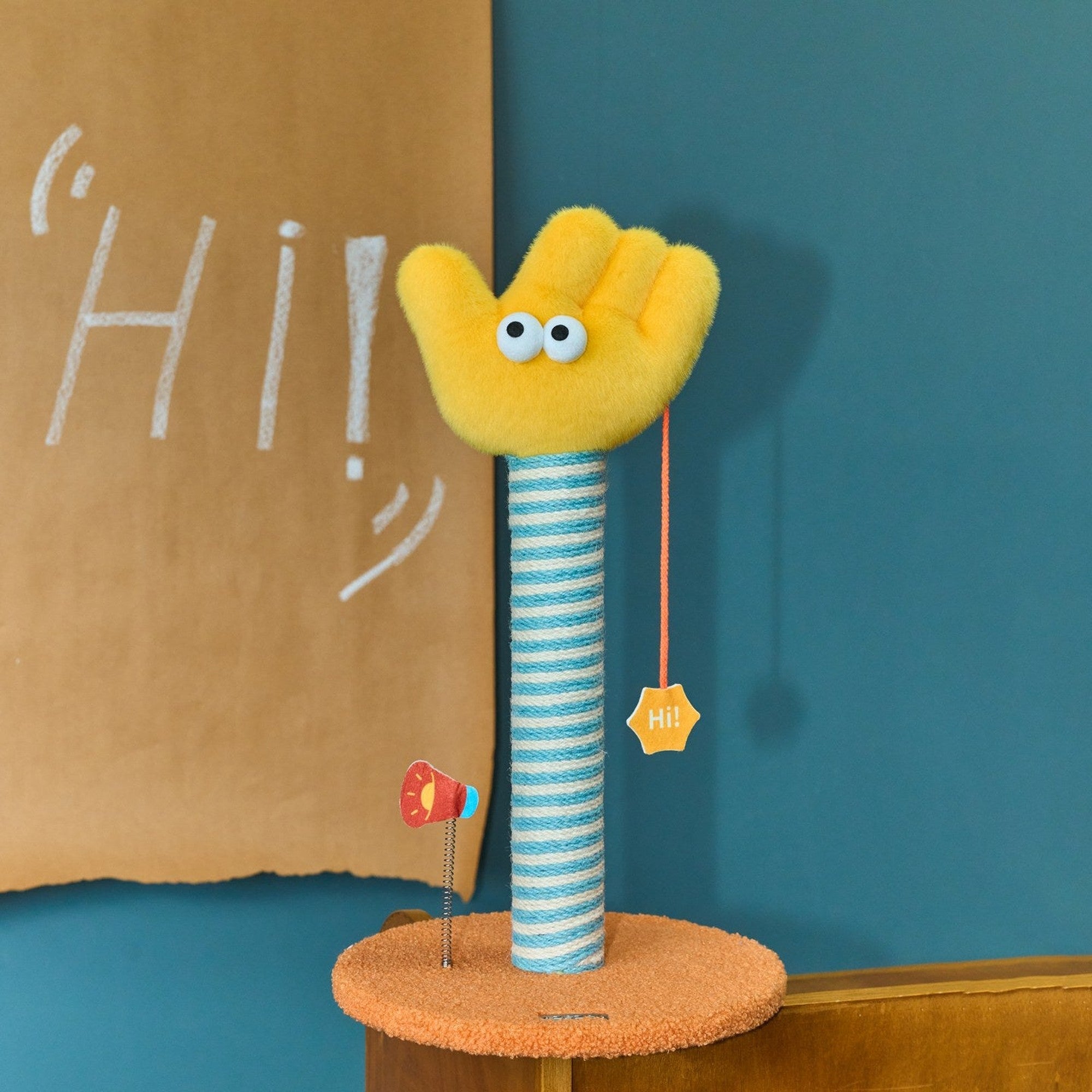Say Hi scratching post in front of a chalk Hi backdrop