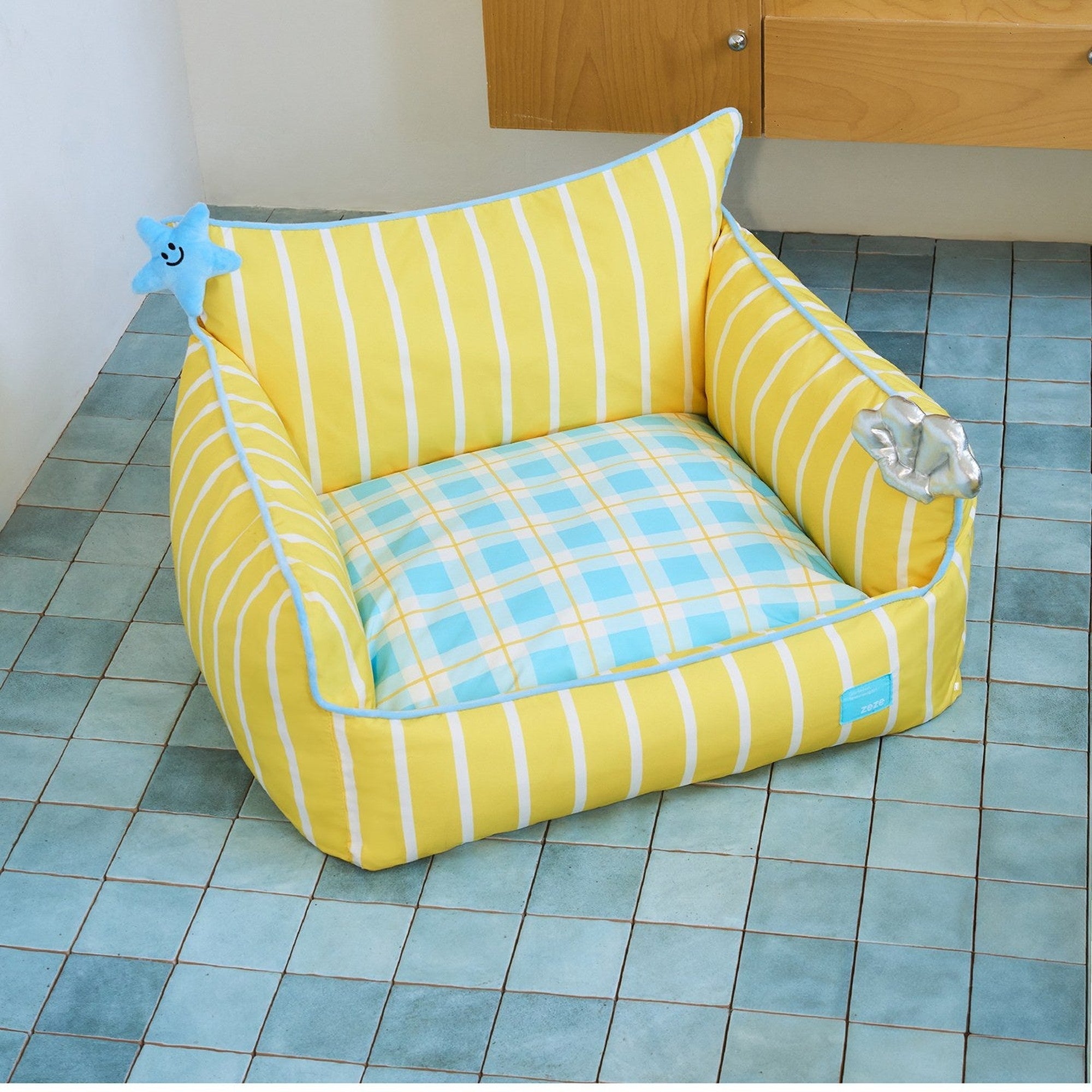 Seashell pet sofa with plaid cushion on a blue tile floor