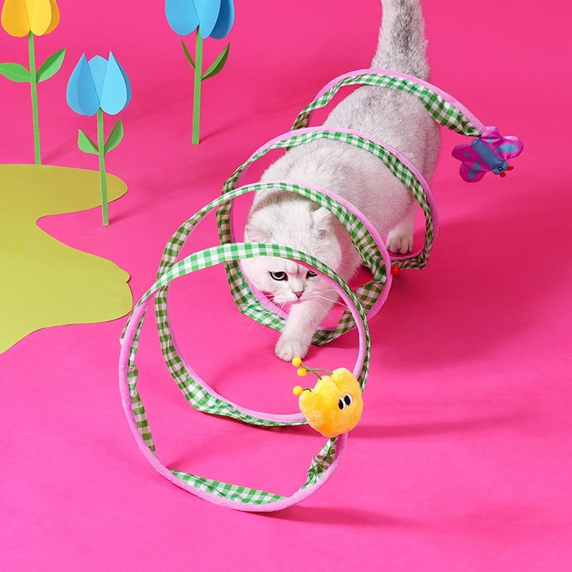 Cat crawling through the extended gingham spiral tunnel