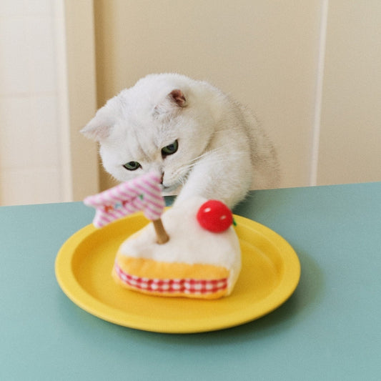 White cat reaching for the ZEZE Strawberry Cake silvervine cat toy