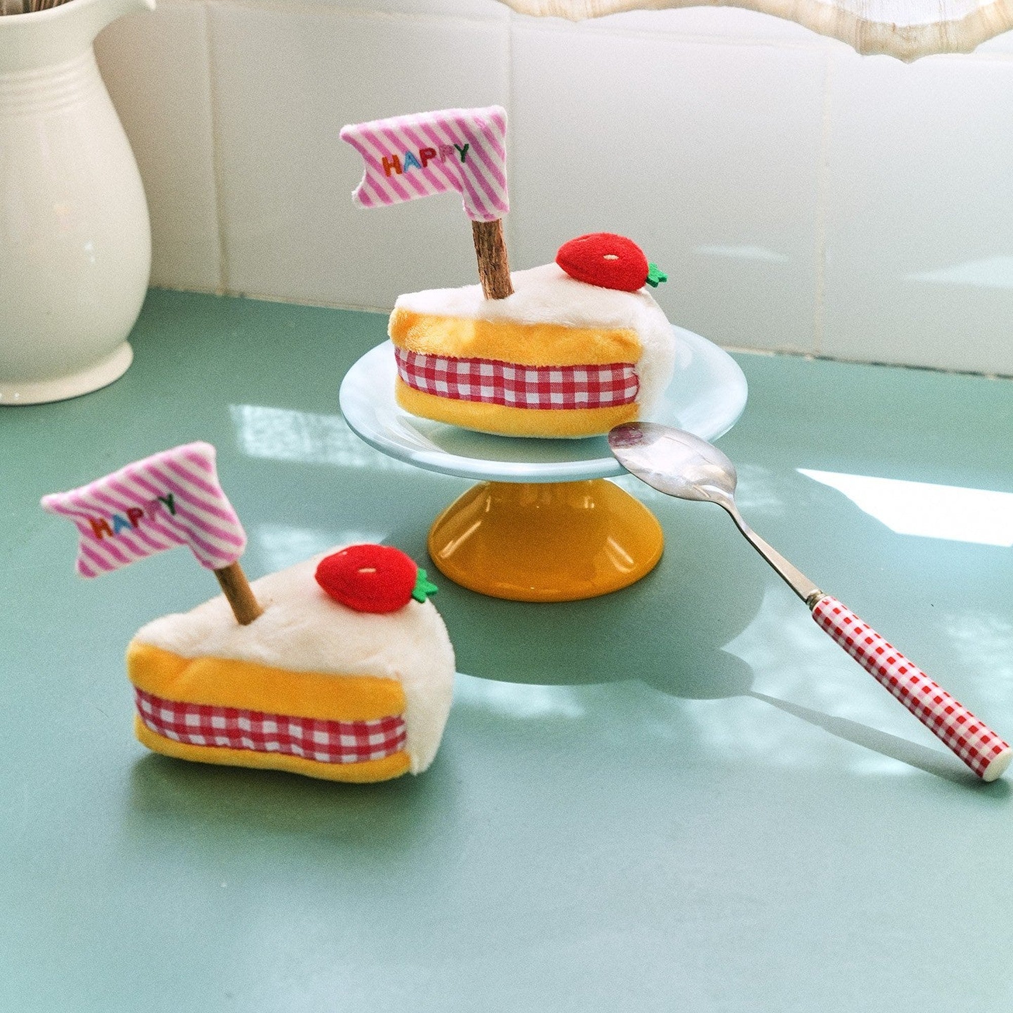 Two strawberry cake cat toys on a cake stand