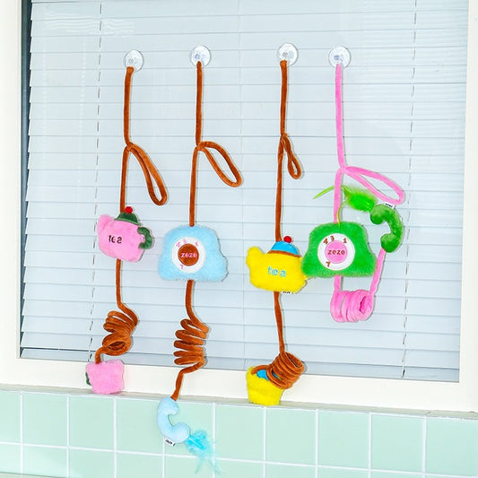 Tea Time teapot toys and Hotline phone toys hanging in a window