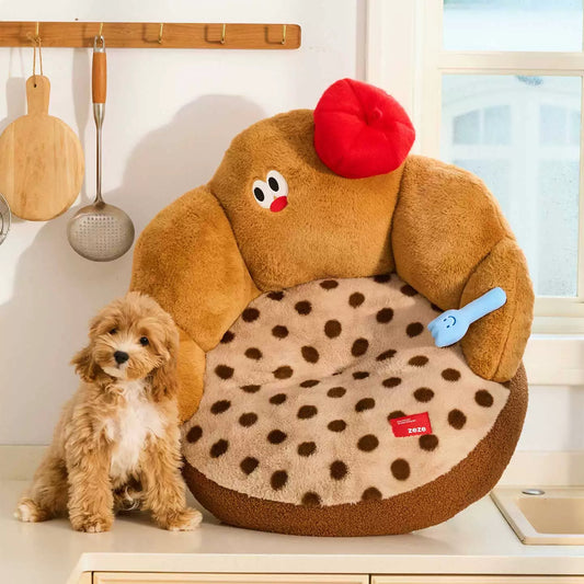 Puppy sitting beside the ZEZE Croissant pet sofa with red beret and fork toy